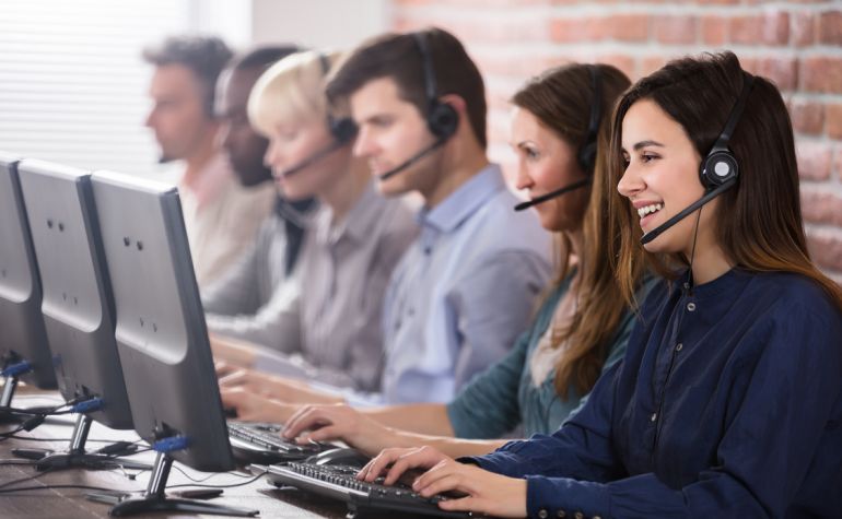 alcuni operatori di call center al lavoro con cuffie e pc