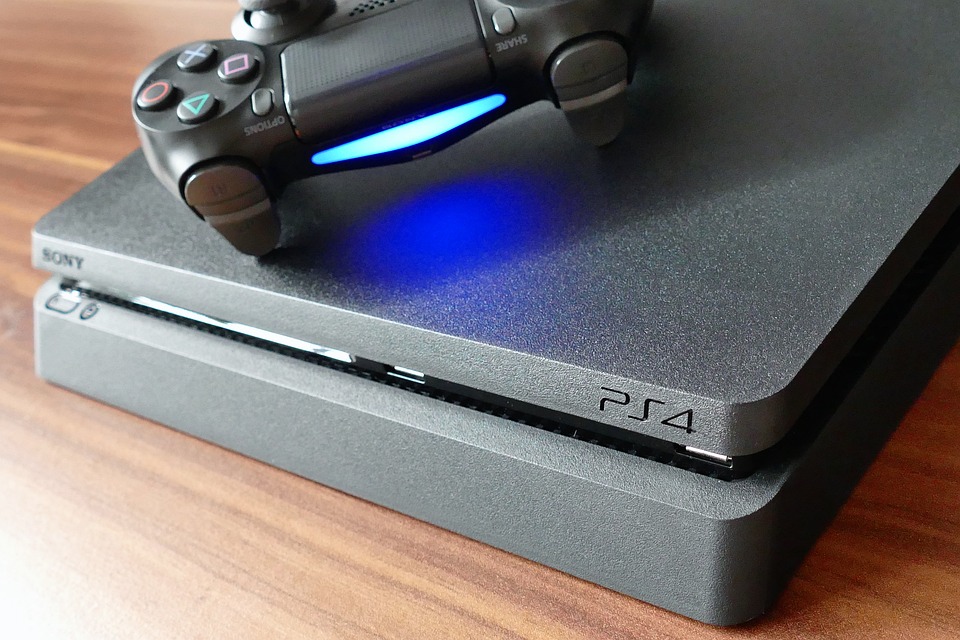 console di gioco Ps4 con joypad su un piano di legno