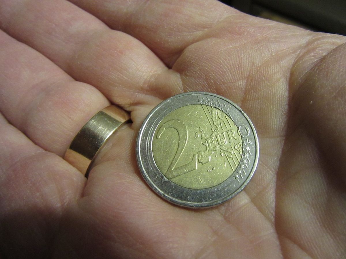 una moneta da 2 euro nel palmo di una mano