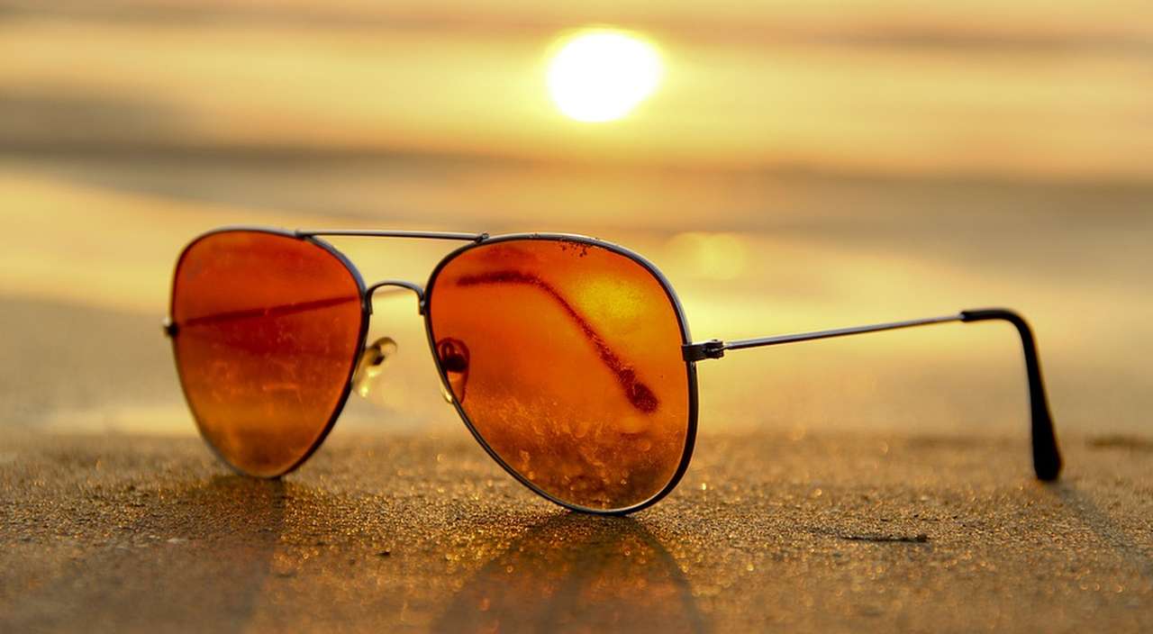 un paio di occhiali da sole posati su un piano alla luce del tramonto