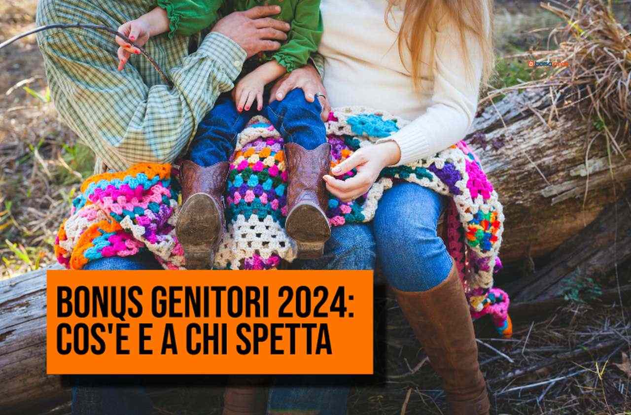 due genitori seduti su un tronco d'albero che tengono in braccio il figlio