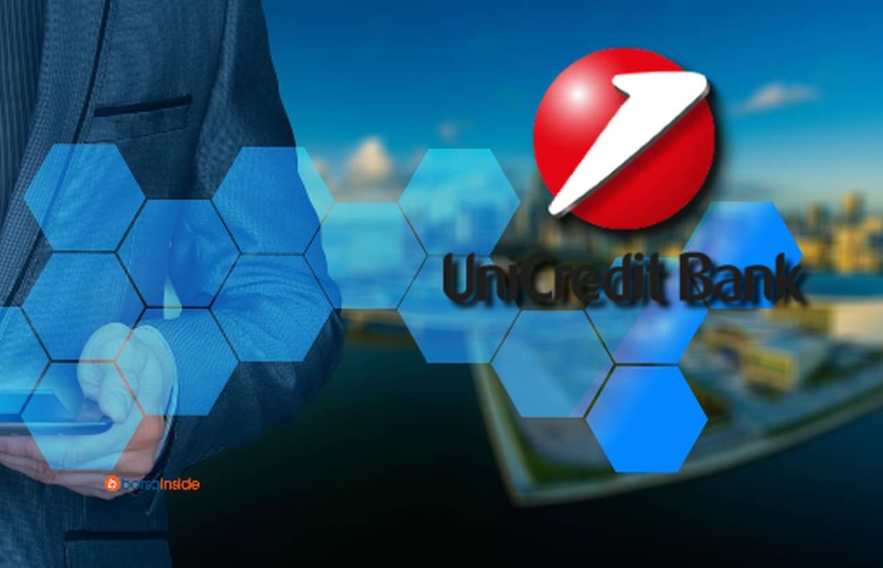 il logo di Unicredit e sullo sfondo il busto di un uomo in giacca e cravatta