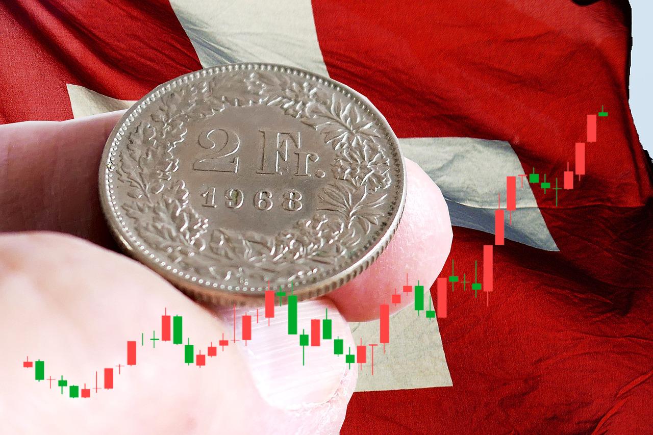 moneta da 2 franchi svizzeri e sullo sfondo bandiera elvetica