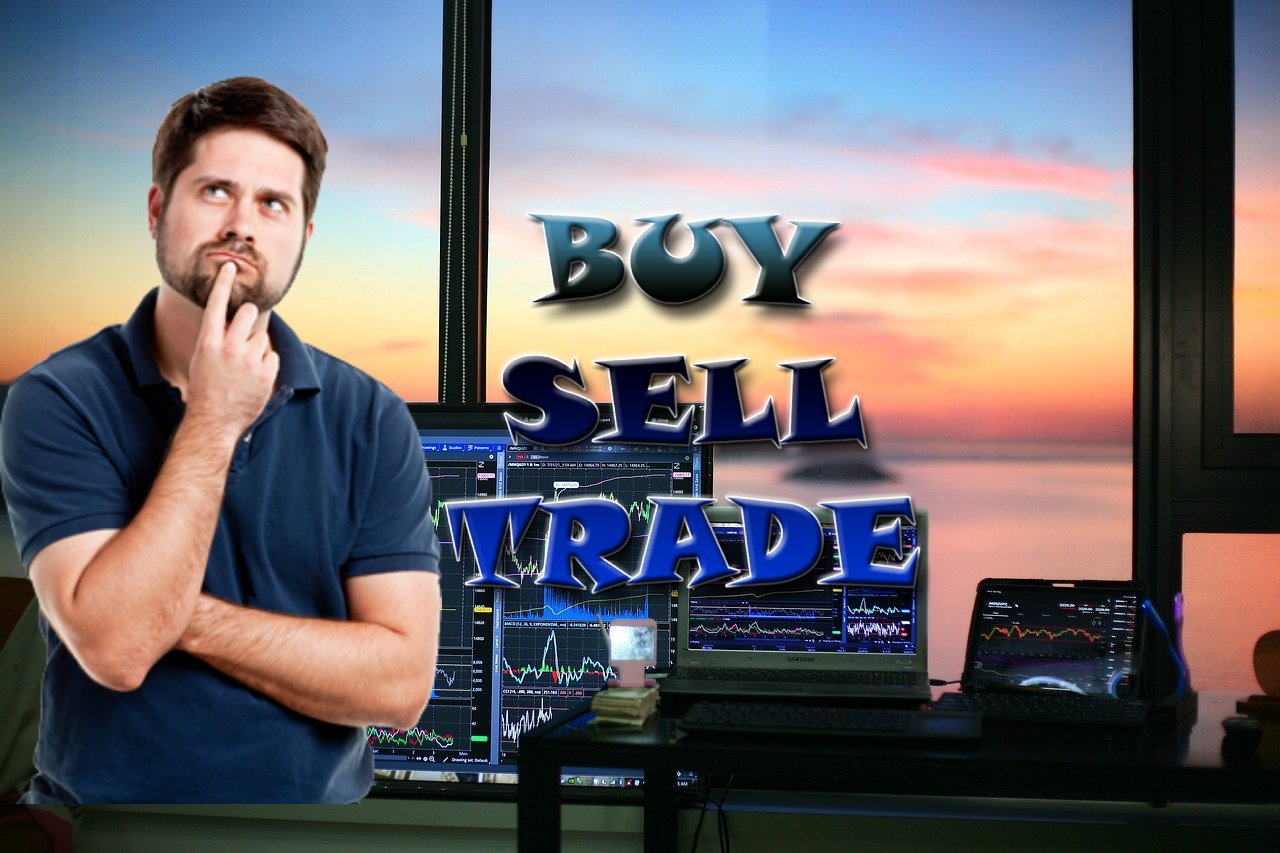 trader che pensa e vari schermi con grafici di trading