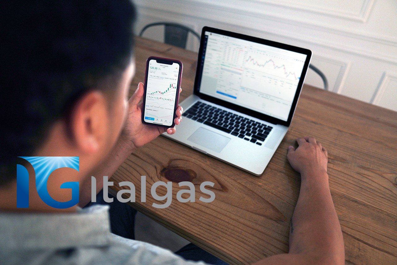 trader al lavoro e logo di italgas