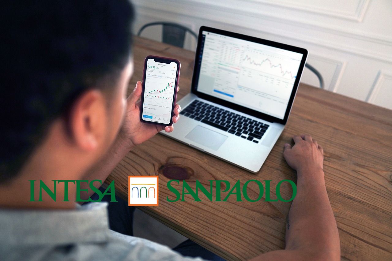 trader in azione e logo di Intesa Sanpaolo