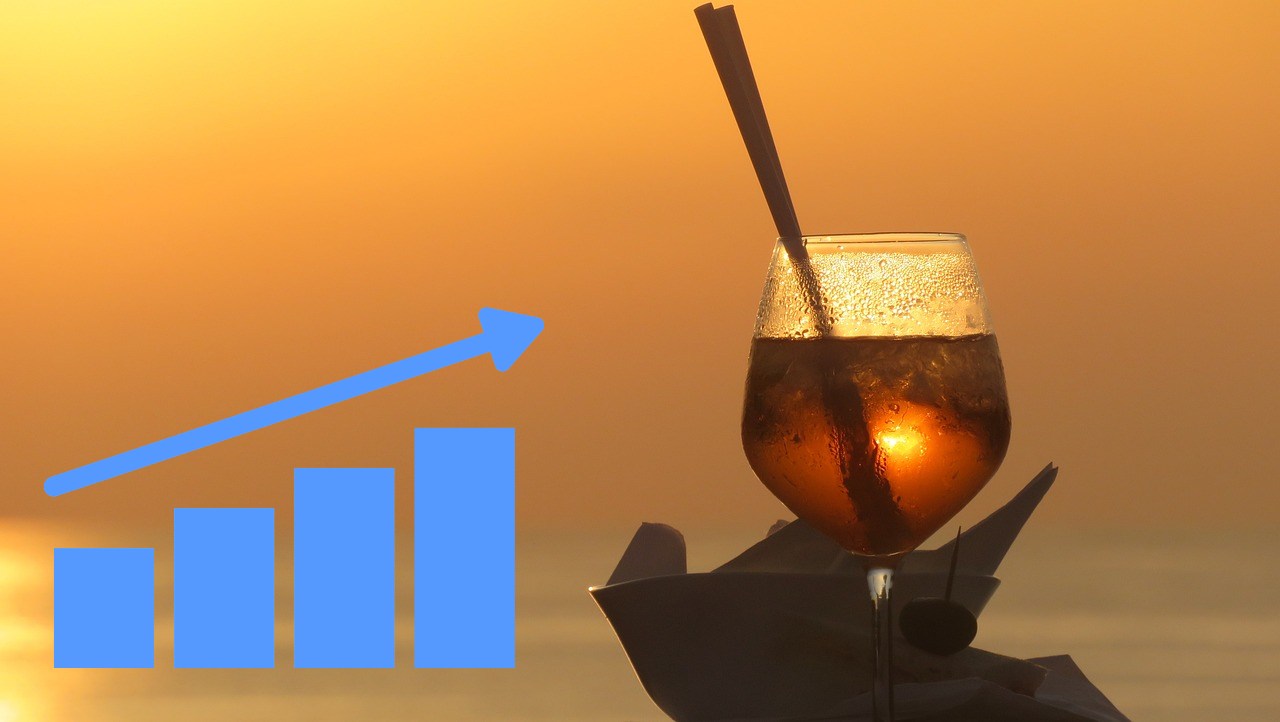 bicchiere con Campari al tramonto e grafico al rialzo