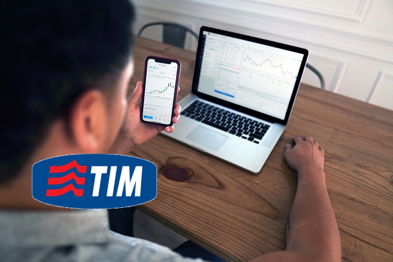 logo di Telecom Italia e trader in azione